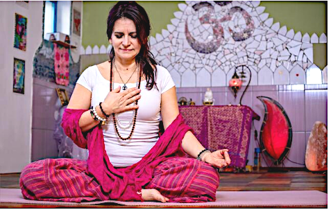 Une femme méditant en posture du lotus, avec un mala de Rudraksha autour du coup