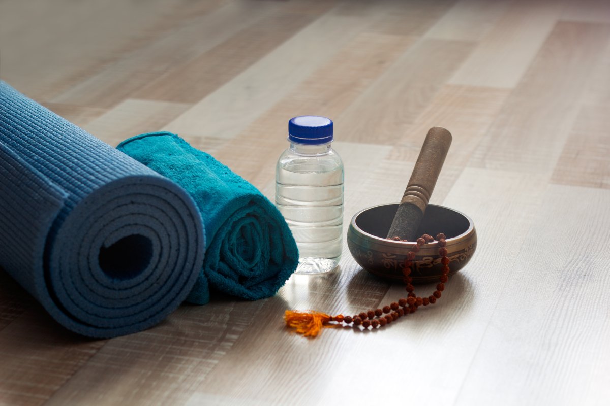 tapis de yoga avec un mala rudraksha, un bol chantant et une bouteille d'eau